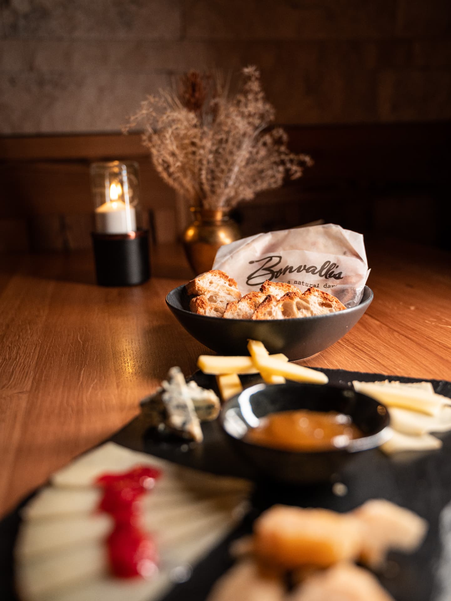 Käseplatte mit geröstetem Brot und Chutney im Kerzenschein